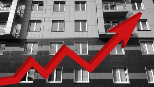 Red growing up large arrow on residential building monochrome background. Mortgage rate increase. Apartment price rise. Sale and rental Flat. Bar chart and graph. Real estate. Inflation. Economics.